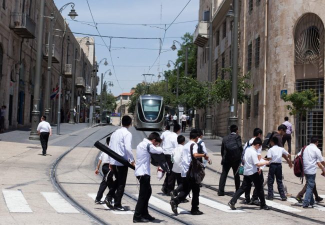 נערים חוצים את הרכבת הקלה בכיכר צה''ל | צילום: ניל בדשא/פלאש 90